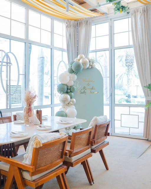 Baby shower table setting with pastel balloons beside bright windows, posted 8 October 2026