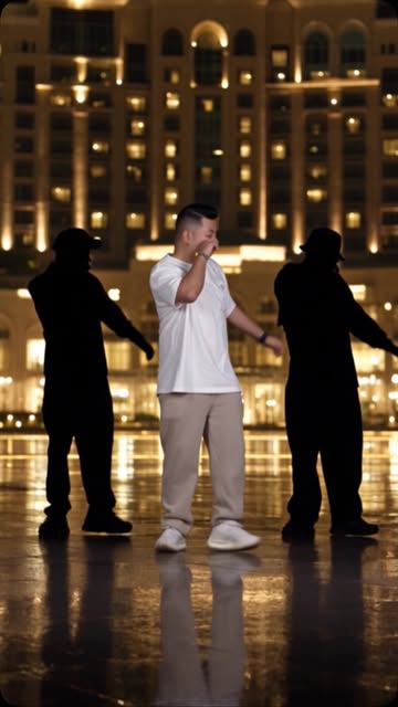 Three dancers in front of an illuminated building at night, posted 10 October 2026